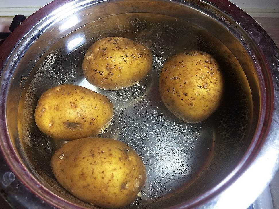 Картошку варить в холодной или горячей воде. Картофель в мундире. Отварная картошка в мундире. Картофель варится. Варёная картошка в кострюле.